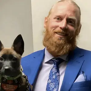 Darby Jones in a suit, with his dog